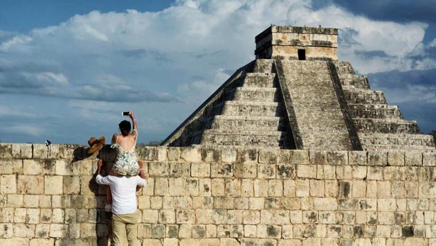 A woman on a man's shoulders takes a picture of the Kukulcan Pyramid at the Mayan archaeological site of Chichen Itza in Yucatan State, Mexico, during the celebration of the spring equinox on March 21, 2018. (Luis Perez / AFP) A woman on a man's shoulders takes a picture of the Kukulcan Pyramid at the Mayan archaeological site of Chichen Itza in Yucatan State, Mexico, during the celebration of the spring equinox on March 21, 2018. (Luis Perez / AFP)