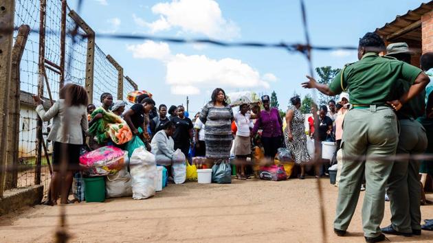 Zimbabwe opposition activist Yvonne Musarurwa (C) stands among other women in a courtyard as she was also about to be released from the Chikurubi Prison, where she was serving a prison term for the killing of a policeman during political clashes. Musarurwa was among 3,000 prisoners pardoned by Mnangagwa in a measure to ease pressure on overpopulated prisons. (Jekesai Njikizana / AFP)