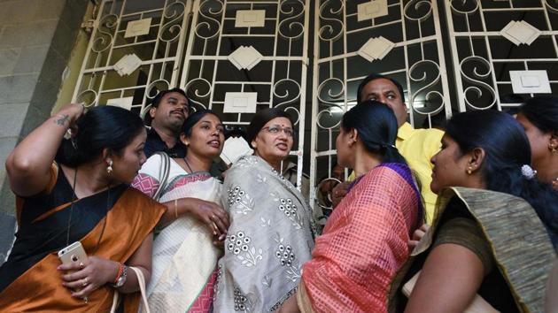 Mayor Mukta Tilak along with corporators stand outside the PMC building gate before a general body meeting on Friday. The day was marked by multiple protests by political parties against the new proposed parking policy. All the gates of the building were closed and no one was allowed to go in or come out for some time due to the protests. (Pratham Gokhale/HT Photo)