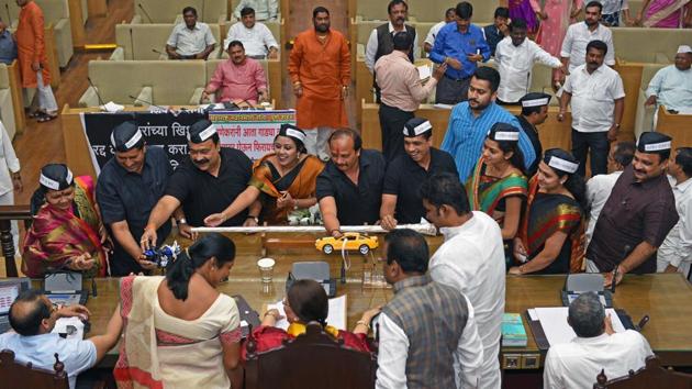 Corporators give toy cars to the mayor and commissioner during a general body meeting to protest against the new proposed parking policy. (Pratham Gokhale/HT Photo)