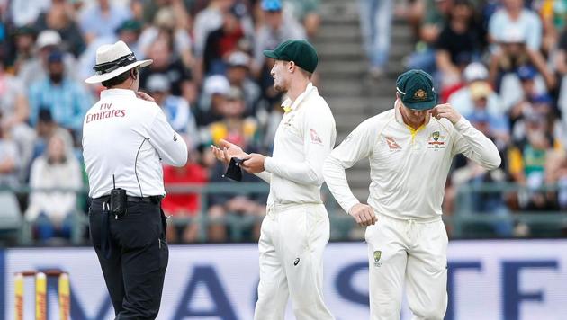 Australian fielder Cameron Bancroft (R) is questioned by umpires during the third day of the third Test against South Africa at Newlands on Saturday.(AFP)