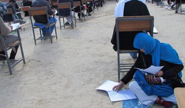Photo, obtained from the Facebook account of Afghan professor Yahya Erfan and taken on March 16, shows Afghan student Jahantab Ahmadi (bottom right) sitting on the ground with her baby on her lap as she takes an entrance exam for Nasir Khusraw private university, in the central city of Nili, the provincial capital of Daykundi province. (AFP) Photo, obtained from the Facebook account of Afghan professor Yahya Erfan and taken on March 16, shows Afghan student Jahantab Ahmadi (bottom right) sitting on the ground with her baby on her lap as she takes an entrance exam for Nasir Khusraw private university, in the central city of Nili, the provincial capital of Daykundi province. (AFP)