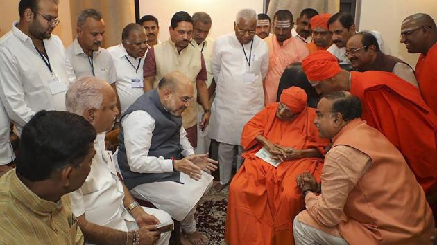 BJP president Amit Shah meets chief pontiff of Siddaganga Mutt Shivakumara Swami, in Tumakuru on Monday.(PTI Photo)