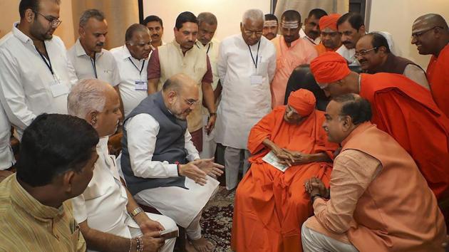 BJP national president Amit Shah began his two-day tour of Karnataka today by seeking blessings of Shivakumara Swamiji of Siddaganga, a prominent Lingayat spiritual guru. (PTI) BJP national president Amit Shah began his two-day tour of Karnataka today by seeking blessings of Shivakumara Swamiji of Siddaganga, a prominent Lingayat spiritual guru. (PTI)