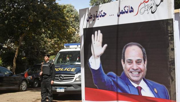 Egyptian policemen stand guard outside a polling station with an electoral banner depicting incumbent President Abdel Fattah al-Sisi, seen in Cairo's central neighbourhood of Zamalek on Monday, (AFP Photo) Egyptian policemen stand guard outside a polling station with an electoral banner depicting incumbent President Abdel Fattah al-Sisi, seen in Cairo's central neighbourhood of Zamalek on Monday, (AFP Photo)