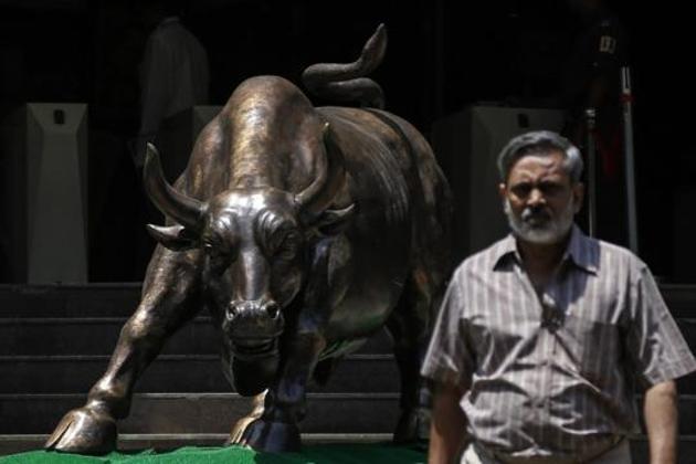 A bronze bull sculpture is seen as an employee walks out of the Bombay Stock Exchange (BSE) building in Mumbai.(Reuters File Photo)