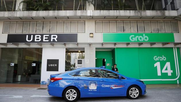 A ComfortDelgro taxi passes Uber and Grab offices in Singapore on Monday. (Reuters Photo) A ComfortDelgro taxi passes Uber and Grab offices in Singapore on Monday. (Reuters Photo)