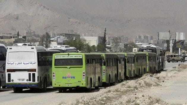 An AFP correspondent at the transfer point in the central Hama province saw 17 buses and ambulances arrive early Sunday with the first wave of evacuees headed to Idlib. Tens of thousands of people bussed out of opposition territory have been brought to Idlib in recent years under “reconciliation” deals like those negotiated in Ghouta. (Louai Beshara / AFP) An AFP correspondent at the transfer point in the central Hama province saw 17 buses and ambulances arrive early Sunday with the first wave of evacuees headed to Idlib. Tens of thousands of people bussed out of opposition territory have been brought to Idlib in recent years under “reconciliation” deals like those negotiated in Ghouta. (Louai Beshara / AFP)