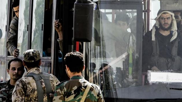 The fighters were searched by Syrian troops, to make sure they left with light weapons only, before Russian military personnel boarded each bus. In the early hours of Monday morning, the buses resumed their journey north to Idlib in the largest single day of evacuations yet for Ghouta. Around 980 left Ghouta in a first batch on Saturday night. (Louai Beshara / AFP) The fighters were searched by Syrian troops, to make sure they left with light weapons only, before Russian military personnel boarded each bus. In the early hours of Monday morning, the buses resumed their journey north to Idlib in the largest single day of evacuations yet for Ghouta. Around 980 left Ghouta in a first batch on Saturday night. (Louai Beshara / AFP)