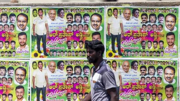 A pedestrian walks past election campaign posters for Karnataka elections 2018 in Bengaluru. (Bloomberg File Photo) A pedestrian walks past election campaign posters for Karnataka elections 2018 in Bengaluru. (Bloomberg File Photo)