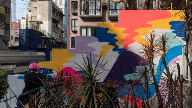 Zoei Lam, a local artist, paints a mural onto a wall in the Sheung Wan district of Hong Kong. Surprisingly, Hong Kong lacks a world-class art museum and marquee exhibitions rarely make a stop in the city, where it can be difficult to secure official permission for public shows. (Philip Fong / AFP) 