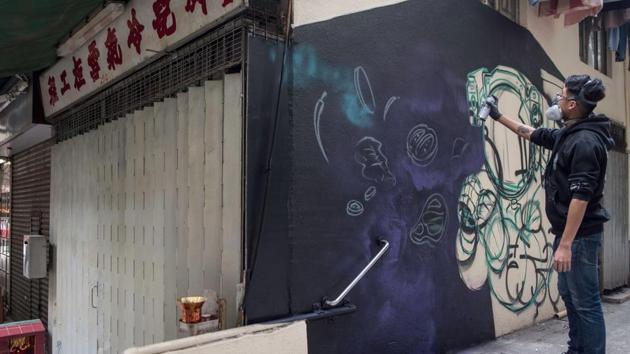 Chinese artist SIK spray paints a mural in the alley of Sai Ying Pun district of Hong Kong. Despite challenges from authorities, street art has enjoyed a boost from growing demand in Asia and an increasing number of exhibitions in recent years, giving it a higher profile and more commercial spin in the city. (Philip Fong / AFP) 
