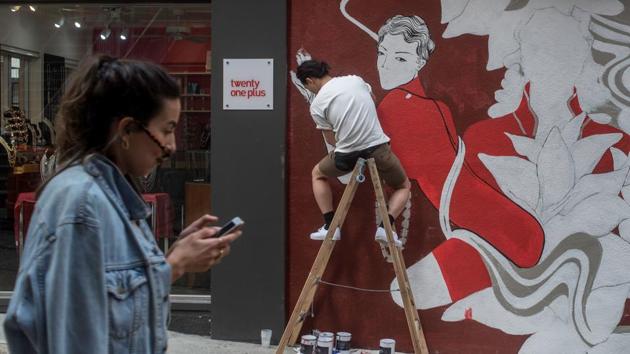 Neil Wang (top C) adds his piece to the city’s walls, already covered with incredible street art. Just opposite the bar Kitchener was spray painting, is a mural by graffiti artist Alex Croft said to be the city’s most photographed wall, featuring rows of old townhouses on a bright blue background. (Philip Fong / AFP) 