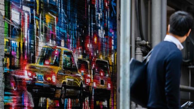 A pedestrian looks at a mural by British artist Dan Kitchener. In 2015, a mosaic of 1970s American cartoon character Hong Kong Phooey by French artist Invader sold at auction in Hong Kong for HK$2 million ($258,000). The popular piece of street art had been destroyed by the city’s authorities, infuriating residents, and was later recreated for sale. (Anthony Wallace / AFP) 