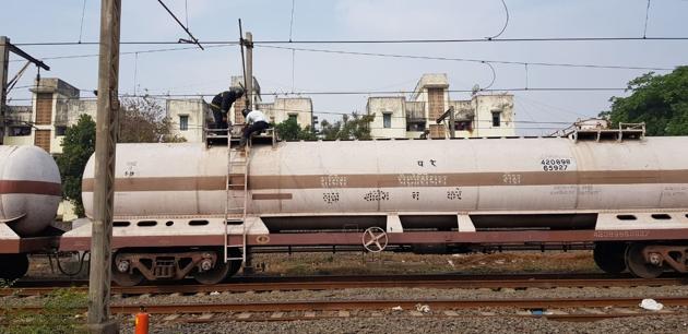 Fire brigade and IOC officials plugging gas leak in a container on a good train in Vasai on Wednesday. (Rahul Birhade) Fire brigade and IOC officials plugging gas leak in a container on a good train in Vasai on Wednesday. (Rahul Birhade)