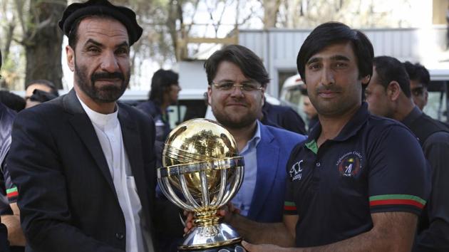 Afghanistan cricket team captain Asghar Stanikzai, right, holds the trophy they won after defeating West Indies in the final of the 2019 ICC World Cup qualification tournament.(AP)