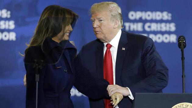 President Donald Trump clasps hands with first lady Melania Trump as he takes the podium to speak at Manchester Community College.(AP File Photo)