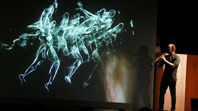 Kinan Azmeh plays the clarinet as Kevork's live sketches create a whirlwind of images in the background during their performance. (REUTERS)