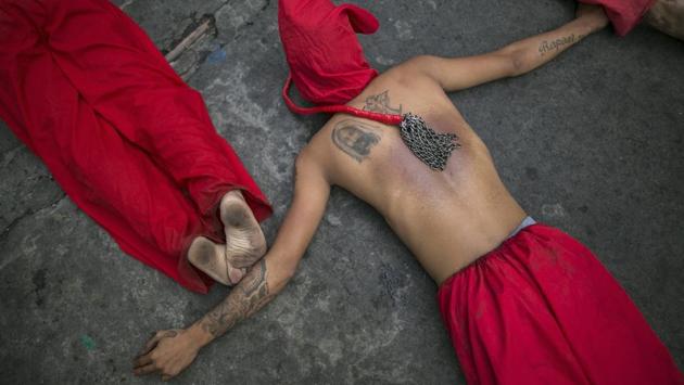 A penitent, with a tattoo of Jesus Christ and his whip resting on his back, lies with other flagellants on a pavement in Mandaluyong City, Philippines. Despite Catholic Church officials discouraging the tradition, Filipinos still practice self-flagellation on Maundy Thursday as a way to atone for sins and commemorate the suffering of Jesus Christ. (AP) A penitent, with a tattoo of Jesus Christ and his whip resting on his back, lies with other flagellants on a pavement in Mandaluyong City, Philippines. Despite Catholic Church officials discouraging the tradition, Filipinos still practice self-flagellation on Maundy Thursday as a way to atone for sins and commemorate the suffering of Jesus Christ. (AP)