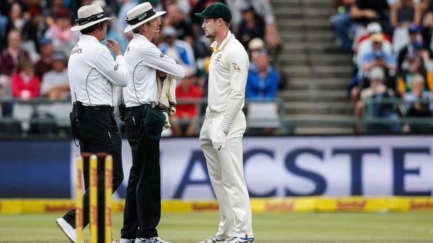 Cameron Bancroft (R) is questioned by umpires during the third day of the third Test between South Africa and Australia at Newlands cricket ground on March 24, 2018 in Cape Town. Bancroft has been banned by Cricket Australia for nine months for ball tampering.(AFP)