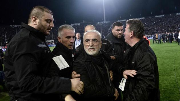 PAOK's Greek-Russian president Ivan Savvidis (C) was escorted out after taking to the pitch carrying a handgun in his waistband during a Greek Superleague match.(AFP)