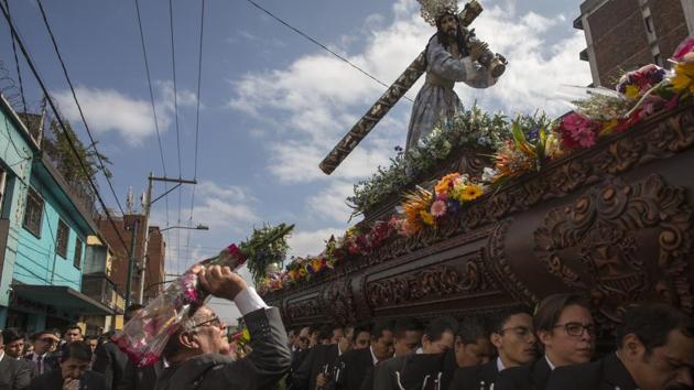 A man tosses a bouquet of flowers on to a religious float during the Jesus of Nazareth procession from La Merced church, in downtown Guatemala City. The procession is known as La Resena and is one of the country's earliest Catholic processions, the first recorded in 1721. (Moises Castillo / AP) A man tosses a bouquet of flowers on to a religious float during the Jesus of Nazareth procession from La Merced church, in downtown Guatemala City. The procession is known as La Resena and is one of the country's earliest Catholic processions, the first recorded in 1721. (Moises Castillo / AP)