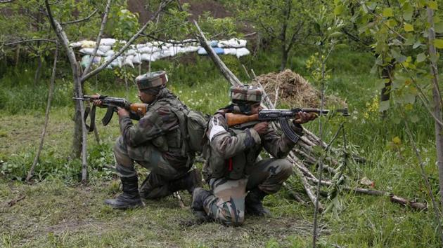 Soldiers take position inside an apple orchard during a search operation in Shopian on Thursday.(AP)