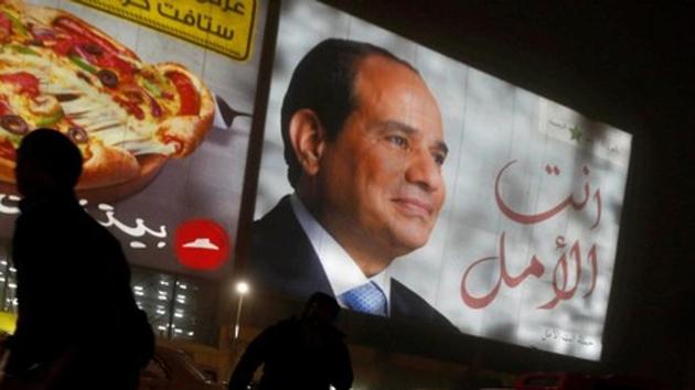 People walk near a billboard showing a picture of Egyptian President Abdel Fattah al-Sisi during the presidential election in Cairo, Egypt, March 28, 2018. (REUTERS) People walk near a billboard showing a picture of Egyptian President Abdel Fattah al-Sisi during the presidential election in Cairo, Egypt, March 28, 2018. (REUTERS)