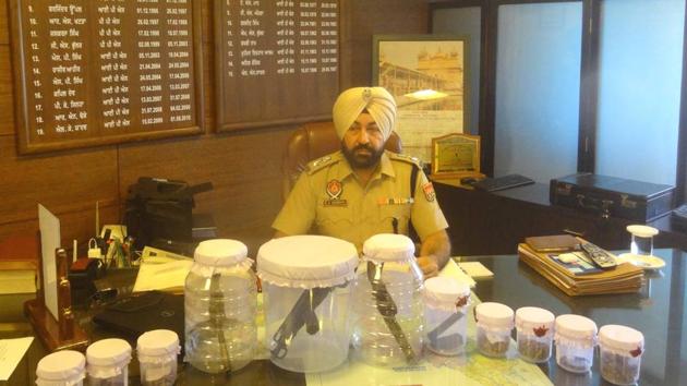 Rupnagar SSP Raj Bachan Singh Sandhu showing arms and ammunition recovered by Rupnagar police on Thursday.(HT Photo)