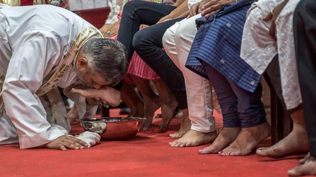 A priest kisses the feet of the 12 disciples after washing it. Jesus washed the feet of his 12 disciples before the Last Supper and thus taught them that if he, as teacher and master, could wash their feet, so also they must do to others. (Satish Bate/HT Photo)
