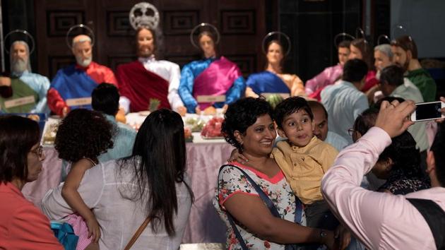 Devotees look at the replica of the Last Supper displayed at Mount Carmel Church, and click photos. (Satish Bate/HT Photo)