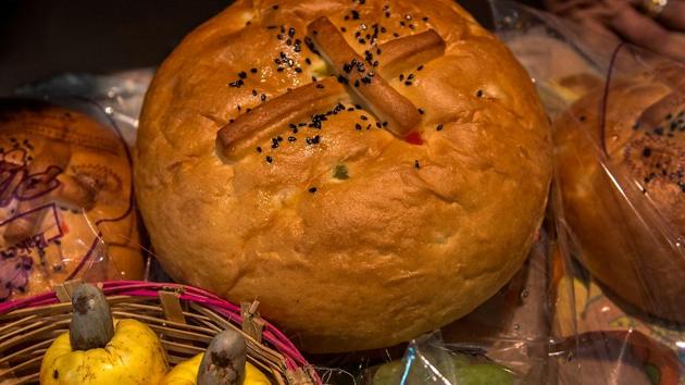 The traditional Easter treat, hot cross buns, and fresh cashew fruit blessed by Father Mascarenhas during the Maundy Thursday service at St Peter’s church. (Satish Bate/HT Photo)