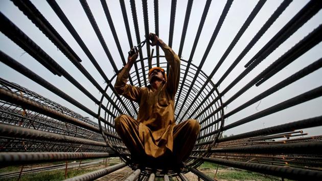 A worker ties steel bars at a construction site for a road in Peshawar, Pakistan. (Fayaz Aziz / REUTERS)