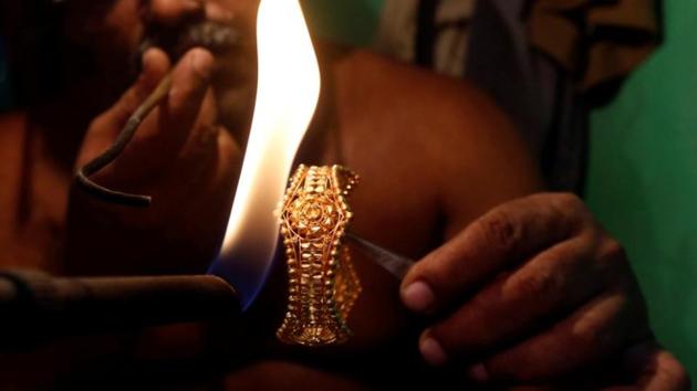 A goldsmith works on a gold bangle at a workshop in Kolkata.(Reuters File Photo)