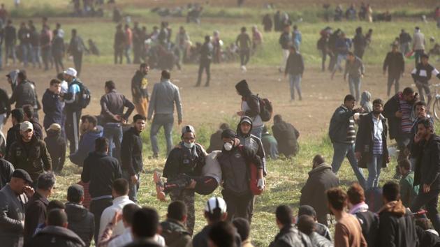 Palestinians carry a wounded protestor during clashes with Israeli security forces as they protest along the border with Israel east of Gaza City to commemorate Land Day on Friday. (AFP Photo) Palestinians carry a wounded protestor during clashes with Israeli security forces as they protest along the border with Israel east of Gaza City to commemorate Land Day on Friday. (AFP Photo)