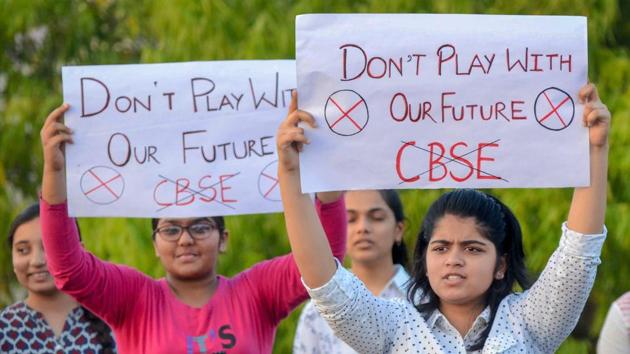 Central Board of Secondary Education (CBSE) students display placards during a protest over the alleged paper leak, in Jabalpur on Friday.(PTI Photo)