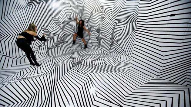 Visitors take a photo in a room called “Darel Carey” by the visual tape and dimensional artist of the same name. The installation uses electrical tape to challenges visual perception. (Mario Anzuoni / REUTERS) Visitors take a photo in a room called “Darel Carey” by the visual tape and dimensional artist of the same name. The installation uses electrical tape to challenges visual perception. (Mario Anzuoni / REUTERS)