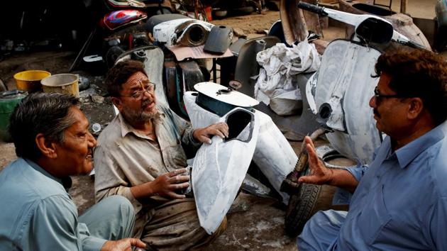 Akram (C) applies coating on scooter parts, as he chats with Vespa owners Farrukh Shahbaz (L) and Matiur Rehman outside his workshop. Shahbaz, who, 14 years ago, inherited his father’s blue 1961 Vespa, has had to have the scooter repaired thrice, but he cherishes the memory and love his father had for the machine. “My father told me it came packed in a wooden box,” Shahbaz said. (Akhtar Soomro / REUTERS) Akram (C) applies coating on scooter parts, as he chats with Vespa owners Farrukh Shahbaz (L) and Matiur Rehman outside his workshop. Shahbaz, who, 14 years ago, inherited his father’s blue 1961 Vespa, has had to have the scooter repaired thrice, but he cherishes the memory and love his father had for the machine. “My father told me it came packed in a wooden box,” Shahbaz said. (Akhtar Soomro / REUTERS)