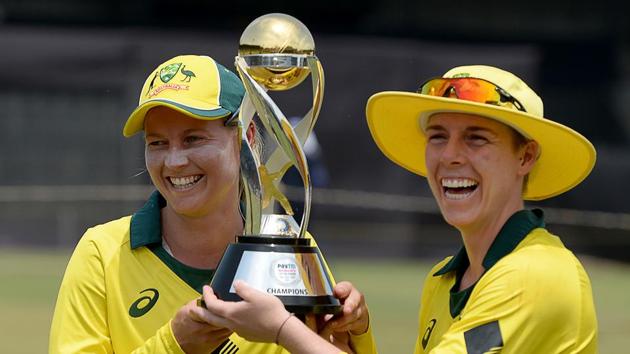Australia cricket team captain Meg Lanning (L) and Elyse Villani pose with the winner’s trophy after defeating England in the women's T20 tri-series final at Brabourne Stadium in Mumbai on Saturday.(AFP)