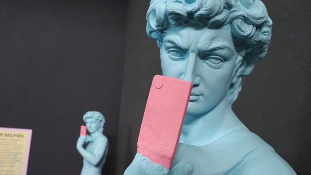 Copies of Michelangelo's statue of David hold cell phones as if mid-selfie themselves. The museum also showcases a record-breaking selfie stick measuring 90-feet, 6 inches, extending through the entire length of the space. (Robyn Beck / AFP) Copies of Michelangelo's statue of David hold cell phones as if mid-selfie themselves. The museum also showcases a record-breaking selfie stick measuring 90-feet, 6 inches, extending through the entire length of the space. (Robyn Beck / AFP)