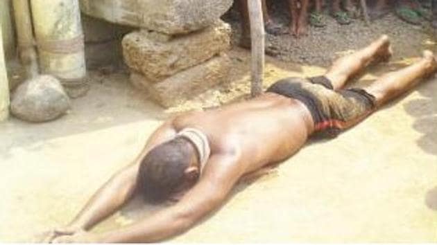 The baby’s father, Ramakrushna Nayak lies prostrate before God, praying for safety of his child in Talabasta village of Odisha’s Cuttack district.(Source: Sambad)