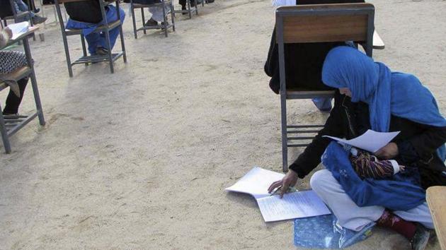 Jahantab Ahmadi, 25, seen sitting cross-legged on a classroom floor with her two-month-old baby asleep on her lap as she takes her university entrance exam in Daikundi in central Afghanistan on March 16.(AP Photo) Jahantab Ahmadi, 25, seen sitting cross-legged on a classroom floor with her two-month-old baby asleep on her lap as she takes her university entrance exam in Daikundi in central Afghanistan on March 16.(AP Photo)