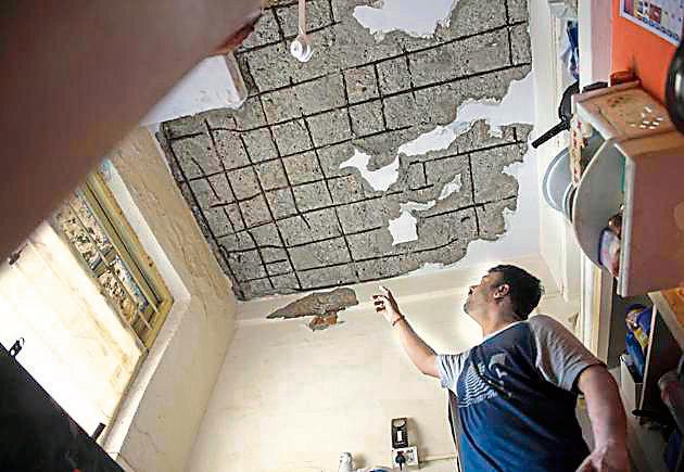 Government Colony resident Santosh Sawant shows the damaged ceiling of his house in Bandra on Saturday.(Satish Bate/HT Photo)