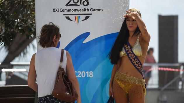 A 'meter maid' stands next to signage for the 2018 Gold Coast Commonwealth Games. (AFP)
