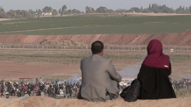 A Palestinian couple sits on sand's hill when Israeli soldiers fire tear gas at protesters during clashes with Israeli troops along the Gaza Strip border with Israel, east of Beit Lahiya, Gaza Strip, March 31. (AP Photo) A Palestinian couple sits on sand's hill when Israeli soldiers fire tear gas at protesters during clashes with Israeli troops along the Gaza Strip border with Israel, east of Beit Lahiya, Gaza Strip, March 31. (AP Photo)