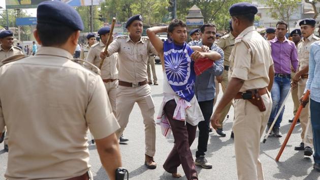 A protester is rounded up by police in Ahmedabad. Demonstrations turned violent in Barmer, Rajasthan where cars and property were reportedly damaged. In Alwar, five people were injured after a shopkeeper opened fire at protesters. (Mujeeb Faruqui / HT Photo)