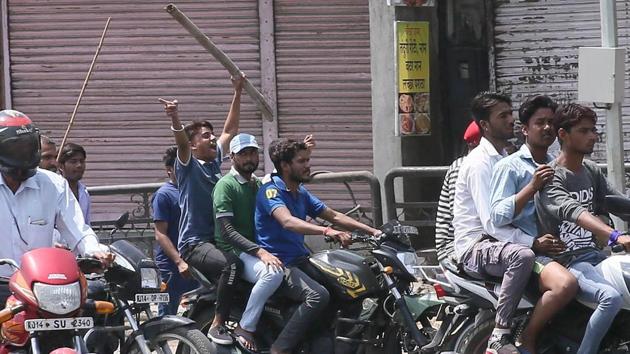 Protesters brandish sticks as they cross closed shops during a bandh in Jaipur on Monday.(Himanshu Vyas/HT Photo) Protesters brandish sticks as they cross closed shops during a bandh in Jaipur on Monday.(Himanshu Vyas/HT Photo)