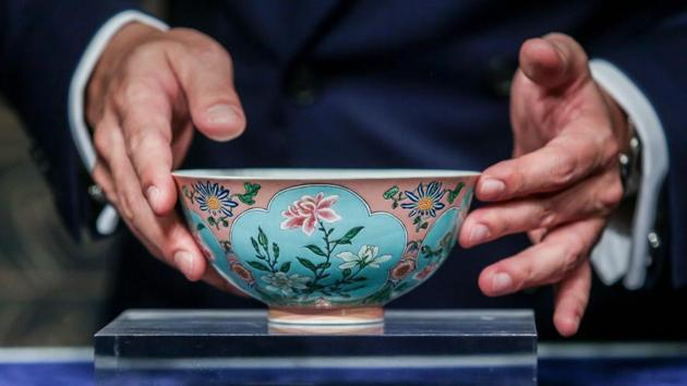 Nicolas Chow, deputy chairman for Sotheby's Asia, holds an extremely rare Qing Dynasty bowl.(AFP)