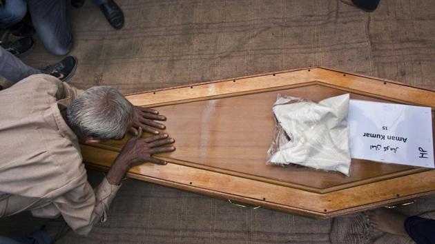 A relative pays his respects to the casket containing the remains of Aman Kumar, who was among the Indian construction workers killed by the Islamic State in Iraq, on April 3, 2018 in Dharmsala, Himachal Pradesh. Prime Minister Narendra Modi on Tuesday announced an ex-gratia of Rs 10 lakh for each of the families of 39 workers killed in Iraq. (Ashwini Bhatia / AP)