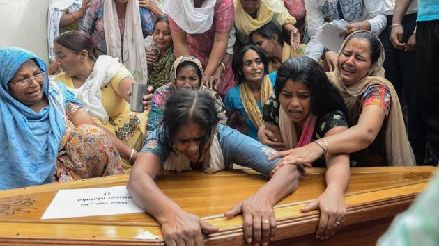 Relatives of construction worker Surjeet Mainka, who was killed in Iraq, grieves over his coffin in Chuhar Wali village on the outskirts of Jalandhar on April 3, 2018.(AFP)